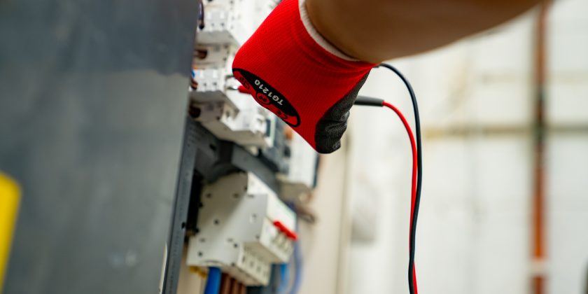 electrician testing circuits and fuses with a multimeter